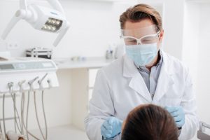 Emergency dentist wearing PPE at appointment 